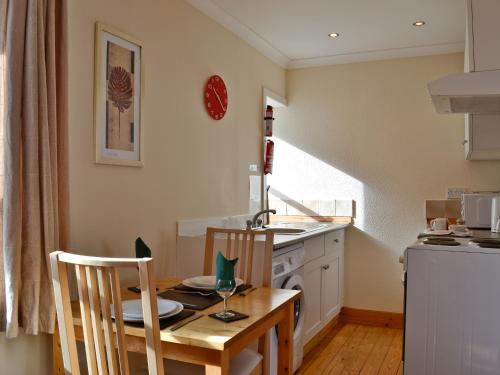 a small kitchen with a table and chairs in a kitchen at Sanna in Ardentinny
