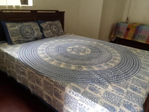 a bed with a blue and white quilt on it at Dune Villa in Hikkaduwa