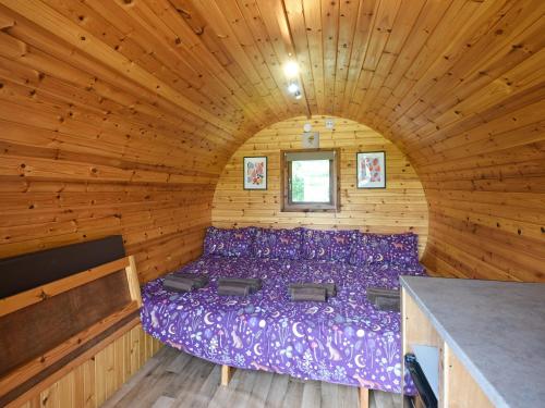 a bedroom with a purple bed in a wooden room at Willow - Glamping Pod - Uk49947 in Oswestry