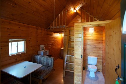 Baño con aseo en una cabaña de madera en Arrowhead Camping Resort Loft Cabin 20, en Douglas Center