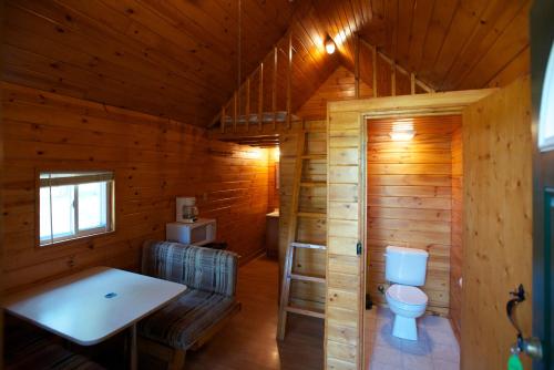 a bathroom with a toilet in a wooden cabin at Arrowhead Camping Resort Loft Cabin 20 in Douglas Center