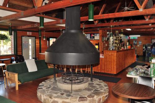 chimenea en una habitación con sofá y mesa en Arrowhead Camping Resort Loft Cabin 20, en Douglas Center