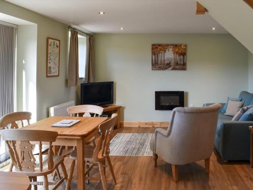 a living room with a table and chairs and a couch at The Barn in Old Brampton
