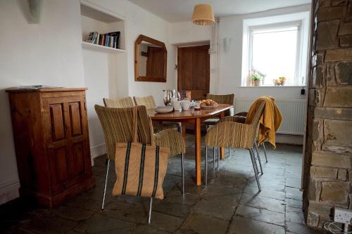 a dining room with a wooden table and chairs at Golan - Ukc4677 in Clynnog-fawr