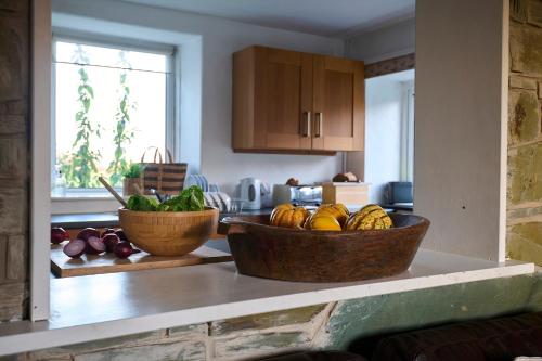 a kitchen with two baskets of fruits and vegetables on a counter at Golan - Ukc4677 in Clynnog-fawr