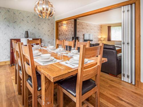 a dining room with a wooden table and chairs at Beinn View House in Cononbridge