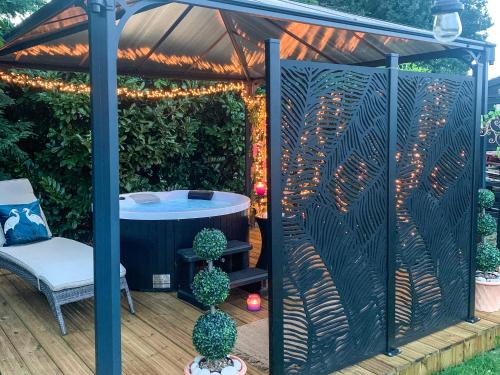 a gazebo with a hot tub in it at Holly's Hidden Hideaway - Uk36783 in Sutton Valence