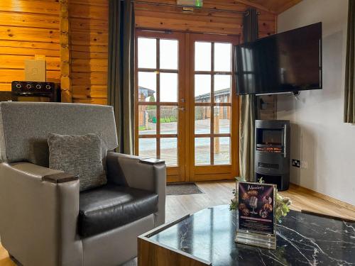 a living room with a couch and a tv and a table at Lodge 5 - Uk51251 in Glasgow
