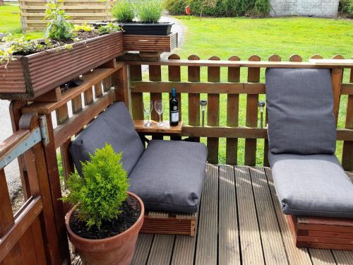a wooden deck with two chairs and a plant at The Revie in Bridlington