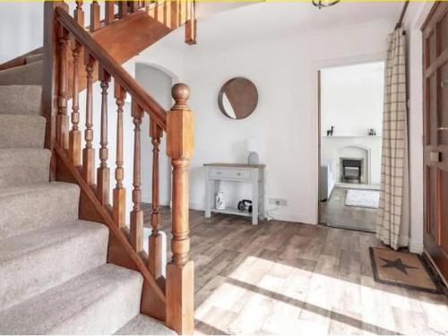 a living room with stairs and a fireplace at Bernicia House in Seahouses