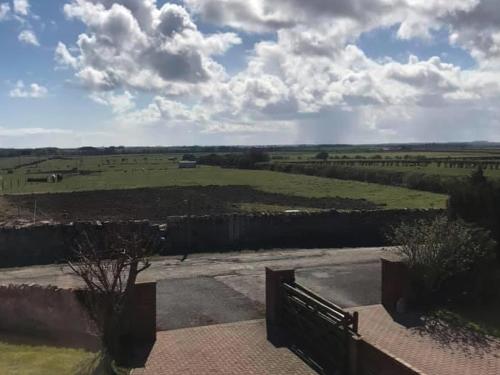 a view of a green field with a fence at Bernicia House in Seahouses