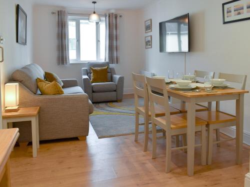 a dining room and living room with a table and chairs at The Snug in Bowness-on-Windermere