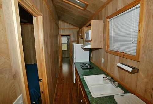 a small kitchen with a sink and a counter at Arrowhead Camping Resort Deluxe Cabin 14 in Douglas Center