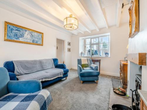a living room with a blue couch and a chair at Lillie's Cottage in Sewerby