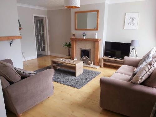 a living room with two couches and a fireplace at Croeso in Conwy