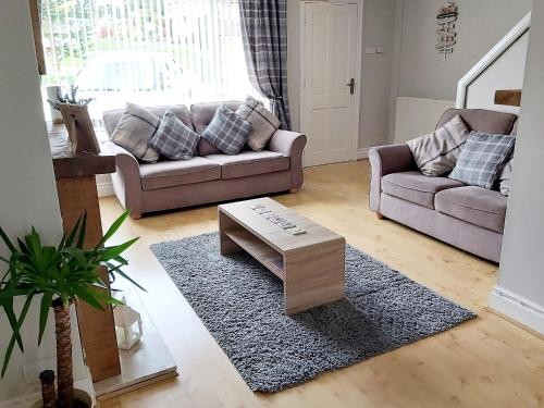 a living room with a couch and a coffee table at Croeso in Conwy