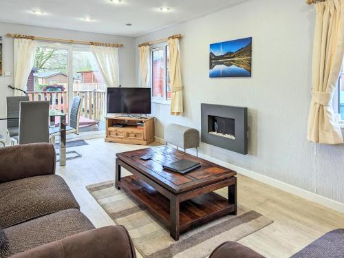 a living room with a coffee table and a flat screen tv at Bowness Lodge 12 Fellside in Windermere