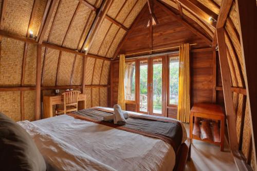 a bedroom with a bed in a wooden room at The Tandjung Cottage in Nusa Penida