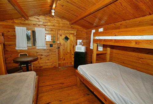 a bedroom with a bed in a wooden cabin at Arrowhead Camping Resort Cabin 1 in Douglas Center