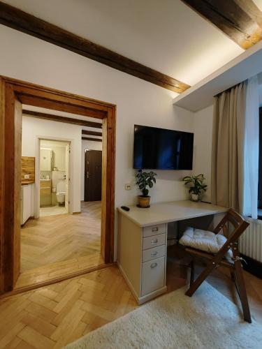 ein Heimbüro mit Schreibtisch und einem Fernseher an der Wand in der Unterkunft La Garcon in Braşov