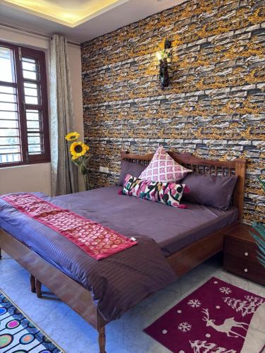 a bed in a room with a brick wall at Whispering Vines by Blessings in Rishīkesh