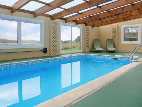 a swimming pool in a house with windows at Barn Owl Cabin - Uk45401 in Forfar