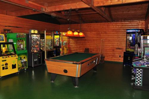 a room with a pool table and several arcade machines at Arrowhead Camping Resort Park Model 10 in Douglas Center