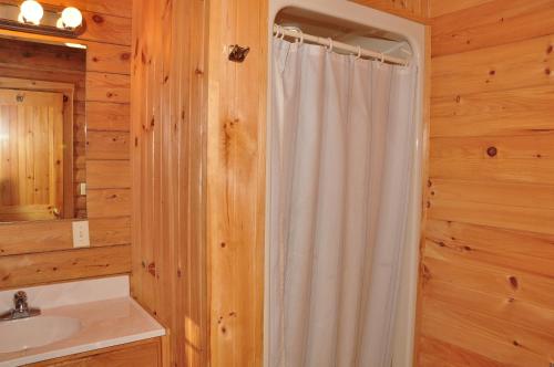 a bathroom with a shower curtain and a sink at Tranquil Timbers Deluxe Cabin 6 in Sturgeon Bay
