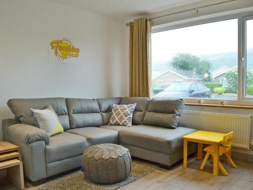 a living room with a couch and a large window at Lle Clyd in Harlech