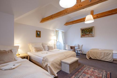 a bedroom with two beds and a table and chairs at Penzion Nad Kašnou in Kašperské Hory