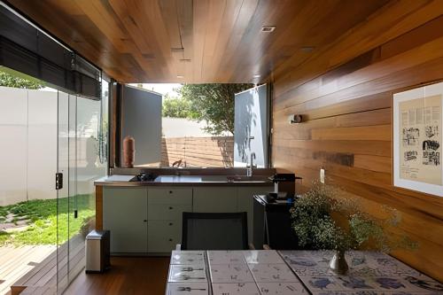 a kitchen with wooden walls and a large window at Casa Pantuso - Vale do Sol in Nova Lima