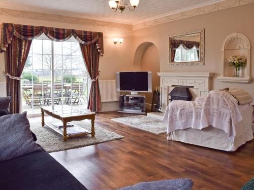 a living room with a fireplace and a tv at New Inn House in Harvington