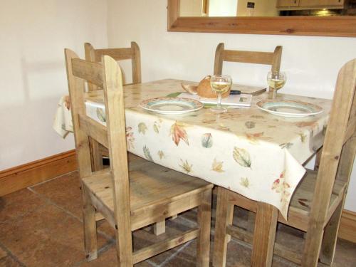 a table with two chairs and a table with glasses of wine at Rievaulx Cottage in Filey
