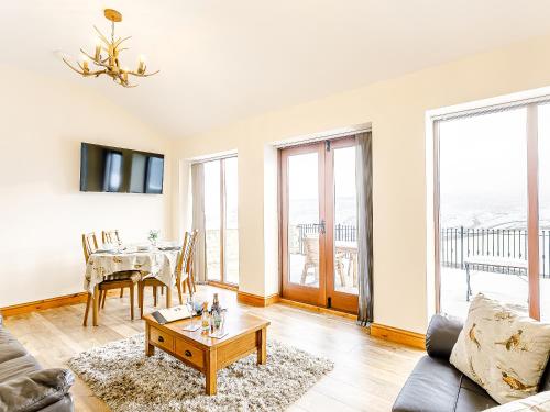 a living room with a table and a couch at Water's Edge - Uk32390 in Dunford Bridge