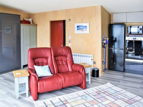 a red chair sitting in a living room at The Duckling in Port na Long