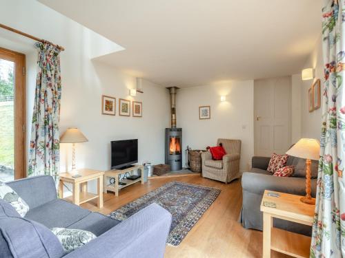 a living room with a couch and a tv at Hopewell Barn in Hewelsfield