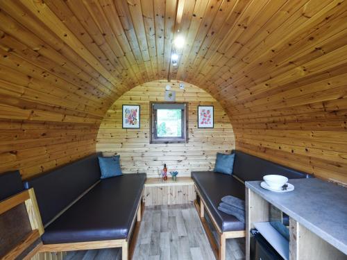 a room in a log cabin with benches and a table at Beech - Glamping Pod - Uk49945 in Oswestry
