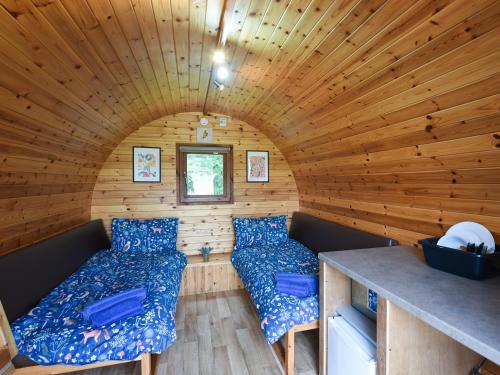 a room with two beds in a wooden cabin at Beech - Glamping Pod - Uk49945 in Oswestry
