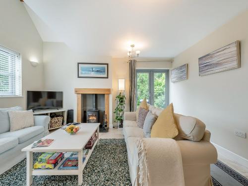 a living room with a couch and a table at Windsmoor Cottage On Gower in Penrice