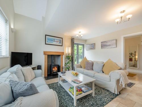 a living room with two couches and a fireplace at Windsmoor Cottage On Gower in Penrice