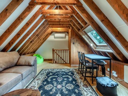 a living room with a couch and a table at The Loft House in Canford Magna