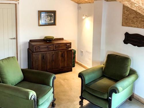 a living room with two chairs and a dresser at The Organic Cabin - Uk42325 in Horsington