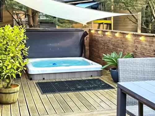a hot tub on a deck with a table and chairs at Chatsworth Lodge - Uk50983 in Felton