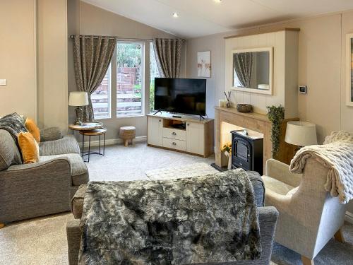 a living room with a fireplace and a television at Chatsworth Lodge - Uk50983 in Felton