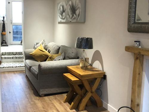 a living room with a couch and a table at Copper Crab Cottage in Amlwch