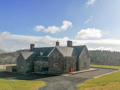 an old stone house with a red door in a field at Colstey Farmhouse in Acton