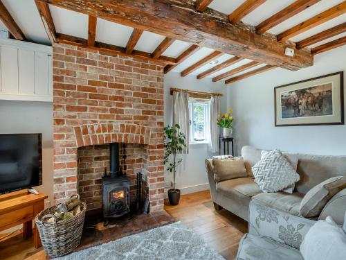 a living room with a brick fireplace and a couch at Swallow Cottages, No 2 - Uk46810 in Thurgarton