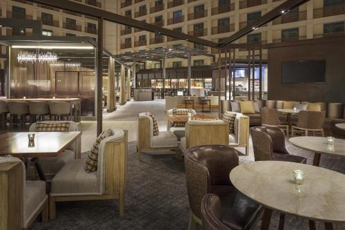 a restaurant with tables and chairs in a building at Hyatt Regency San Francisco Airport in Burlingame