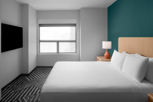a hotel room with a large bed and a window at Hyatt House Pittsburgh-South Side in Pittsburgh