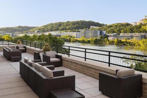 a balcony with chairs and a view of a river at Hyatt House Pittsburgh-South Side in Pittsburgh